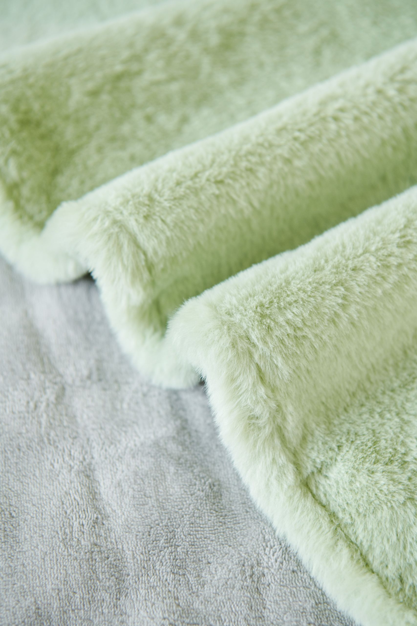 Close-up texture of a soft green fluffy blanket, perfect for cozy themes.